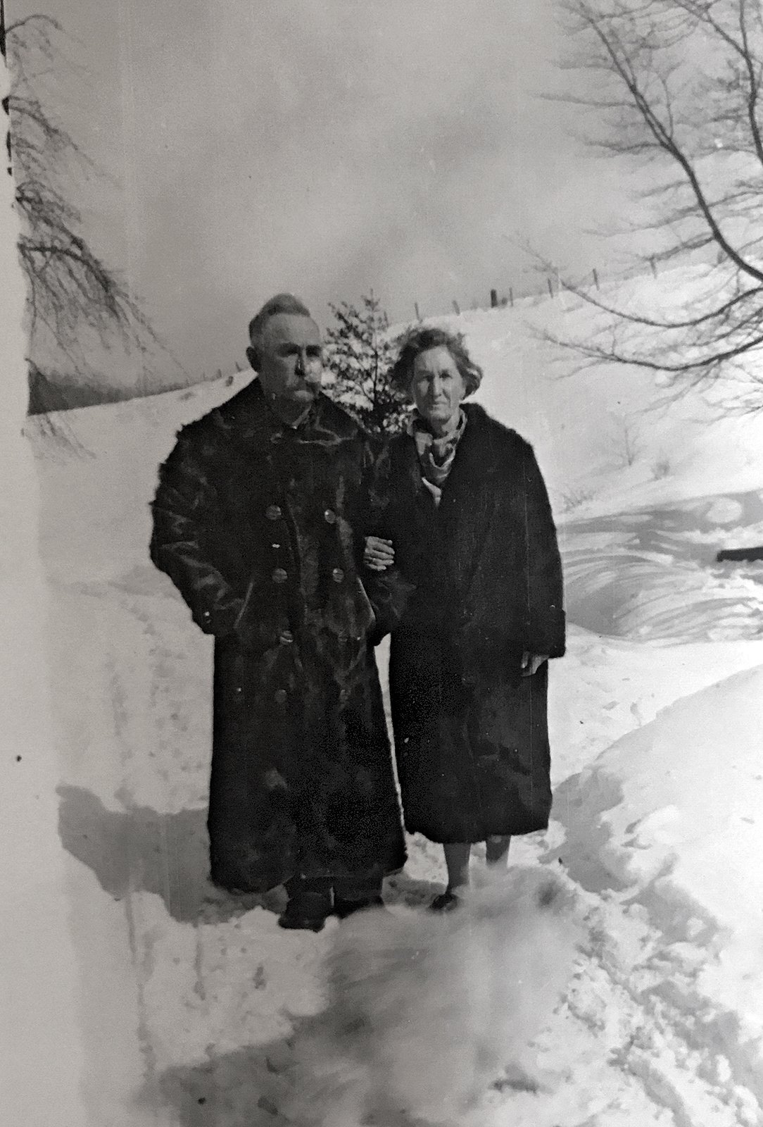 Tressa and husband Frank Yohe walking in the snow on their farm, Pennsylvania, c. 1940s.
