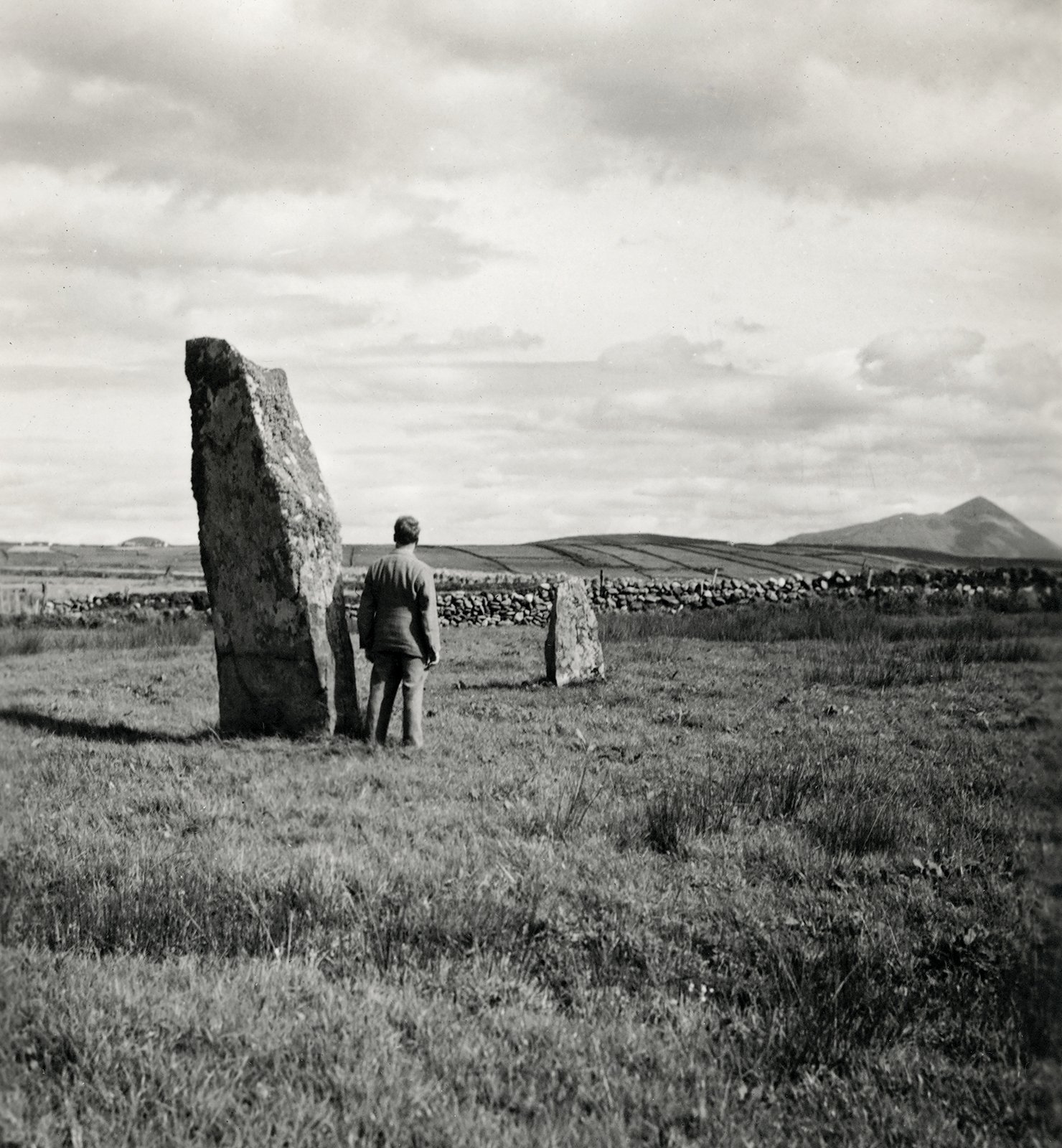 Typically elusive photograph of Ernie O’Malley beside an ancient Standing Stone, County Mayo, 1938. Photograph by Helen Hooker O’Malley.