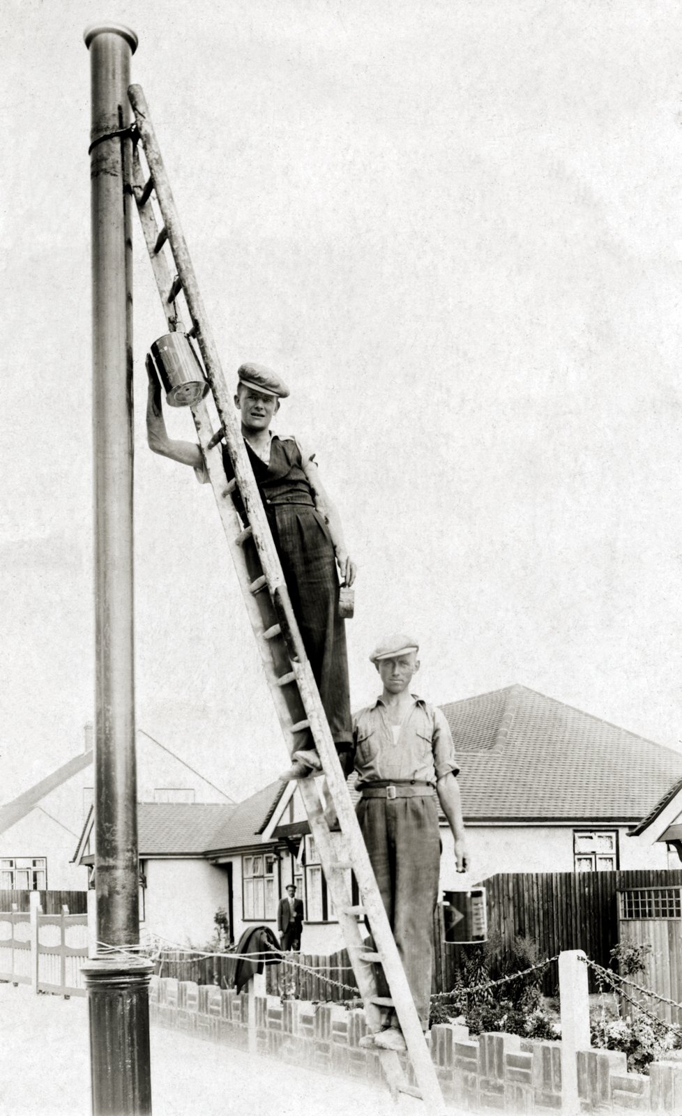 Johnny Murphy (left), a native of Kenmare, County Kerry and Austin McGing (right), a native of Tourmakeady, County Mayo, at work painting a lamppost, London c.1936.